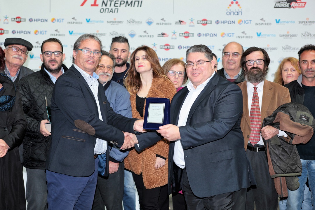Ο COO της Ιπποδρομίες ΑΕ, Κώστας Αλεξόπουλος, παραδίδει τιμητική πλακέτα στους εκπροσώπους της Ιππικής Έκθεσης Ανδραβίδας.